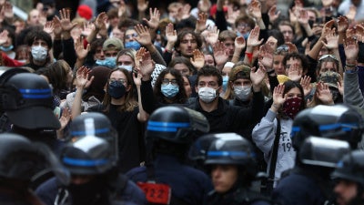 Students raise their hands in front of police officers as they demonstrate outside Sciences Po during a protest over school overcrowding and decay in Paris, France, October 7, 2026. 