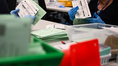 US election workers open and inspect mail-in ballot envelopes during processing inside the Maricopa County Tabulation and Election Center (MCTEC) on Election Day, November 5, 2024, in Phoenix, Arizona.