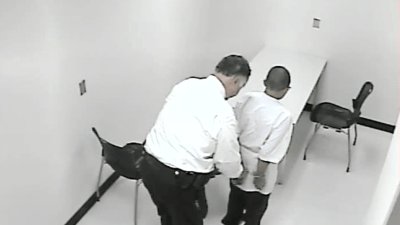 A still from a police interrogation video shows a 13-year-old boy being handcuffed. The pressure of the interrogation caused him to confess to a murder he did not commit. 