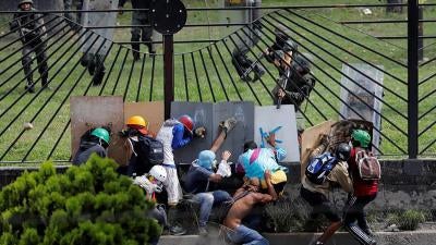 Manifestantes entram em confronto com forças de segurança anti-distúrbio no cercado de uma base aérea enquanto protestam contra o presidente da Venezuela, Nicolas Maduro, em Caracas, Venezuela.
