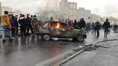 Iranian protesters gather around a burning car during a demonstration against an increase in gasoline prices in the capital Tehran, on November 16, 2019. 