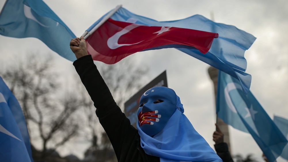 A person from the Uyghur community living in Türkiye protests against the visit of China's Foreign Minister Wang Yi to Türkiye, in Istanbul, March 25, 2021. 