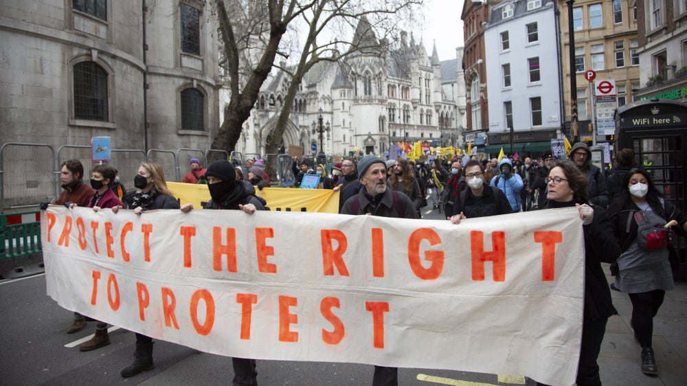 Demonstrators hold a banner that reads "Protect the right to protest"
