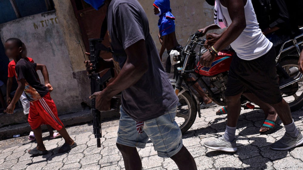Children accompany criminal group members in a march in the Delmas neighborhood of Port-au-Prince, Haiti, May 10, 2024.