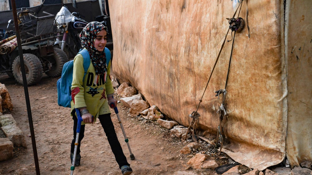 A girl walks to school at an Internally Displaced Persons (IDP) camp in the northwestern Idlib province in Syria, near the Bab al-Hawa border crossing with Turkey, on January 6, 2023.