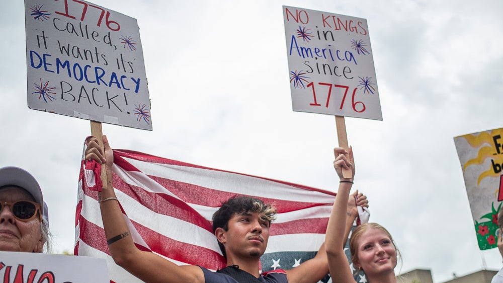 Protesters hold US flags and placards during a nationwide "No Kings" rally