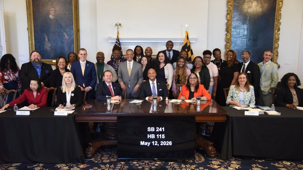 Maryland Governor Wes Moore (center) along with advocates, organizers, and legislators after signing HB 115 and SB 241 at the Maryland State House in Annapolis, May 12, 2026. 