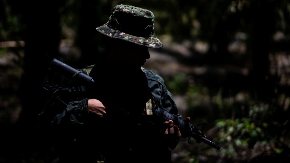 An unidentifiable child soldier holding a gun