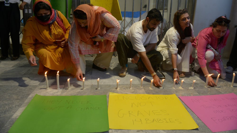 People light candles in memory of the newborn victims outside the Pakistan Institute of Medical Sciences, in Islamabad, Pakistan, August 27, 2026. 