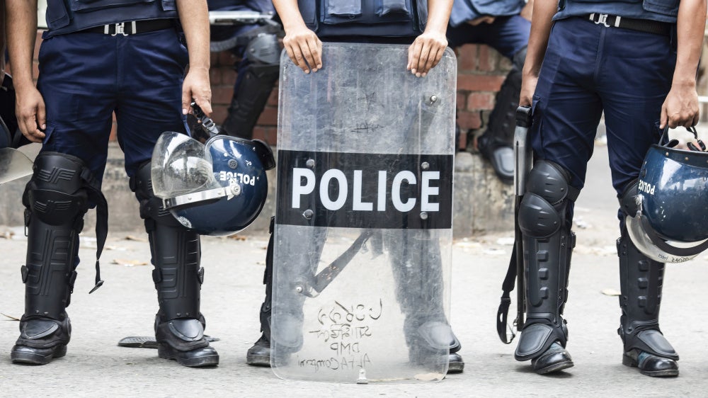 Non-identifiable police officers holding riot shields