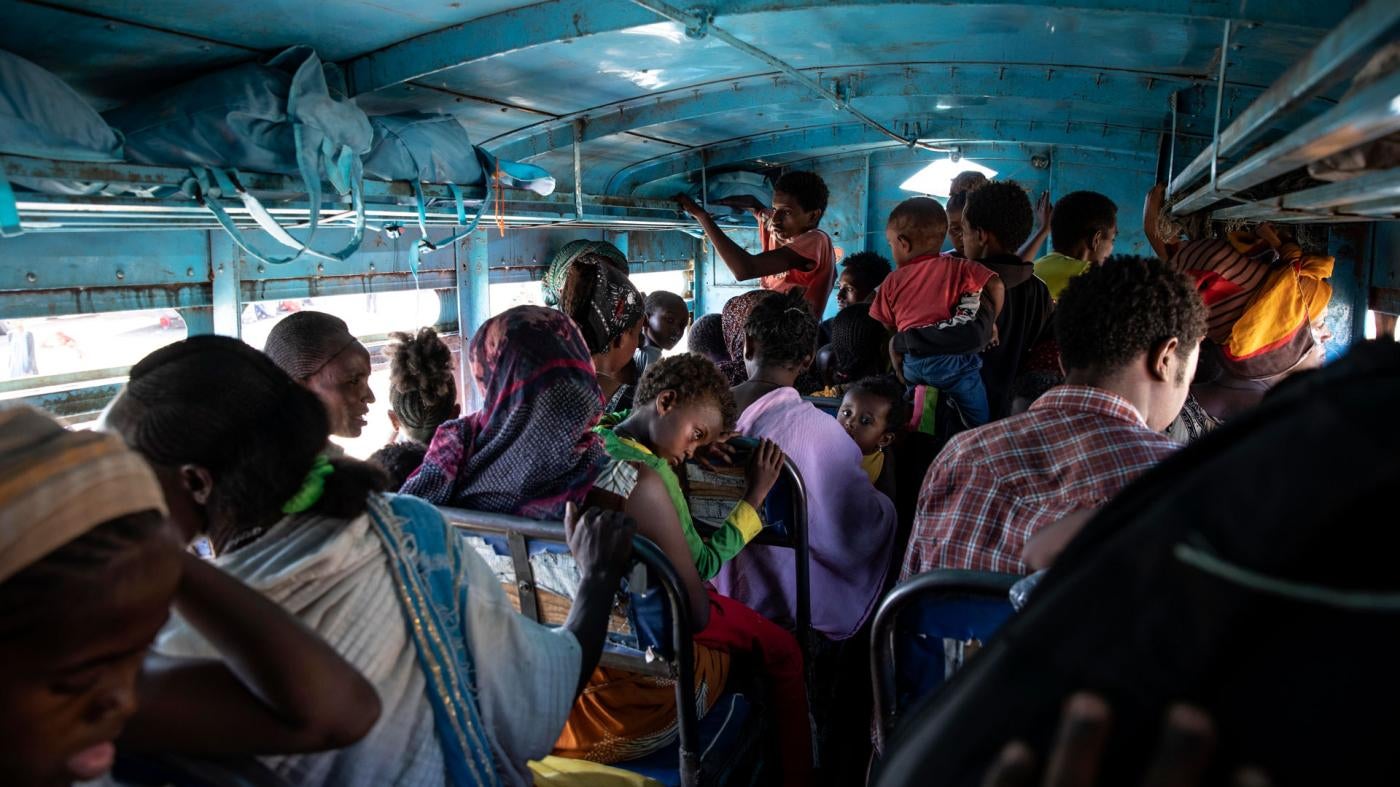 People who fled the conflict in Ethiopia's Tigray region ride a bus to the Village 8 temporary shelter near the Sudan-Ethiopia border, in Hamdayet, eastern Sudan, December 1, 2020. 