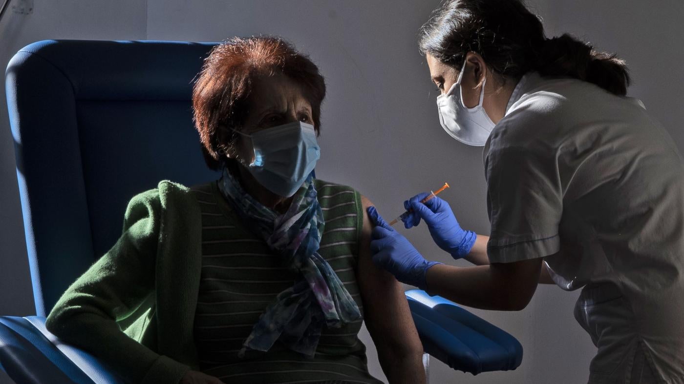 A medical staff member administers a dose of the Pfizer-Biotech vaccine to a person over eighty years old, in the Santa Maria della Pieta hospital in Rome, Italy.