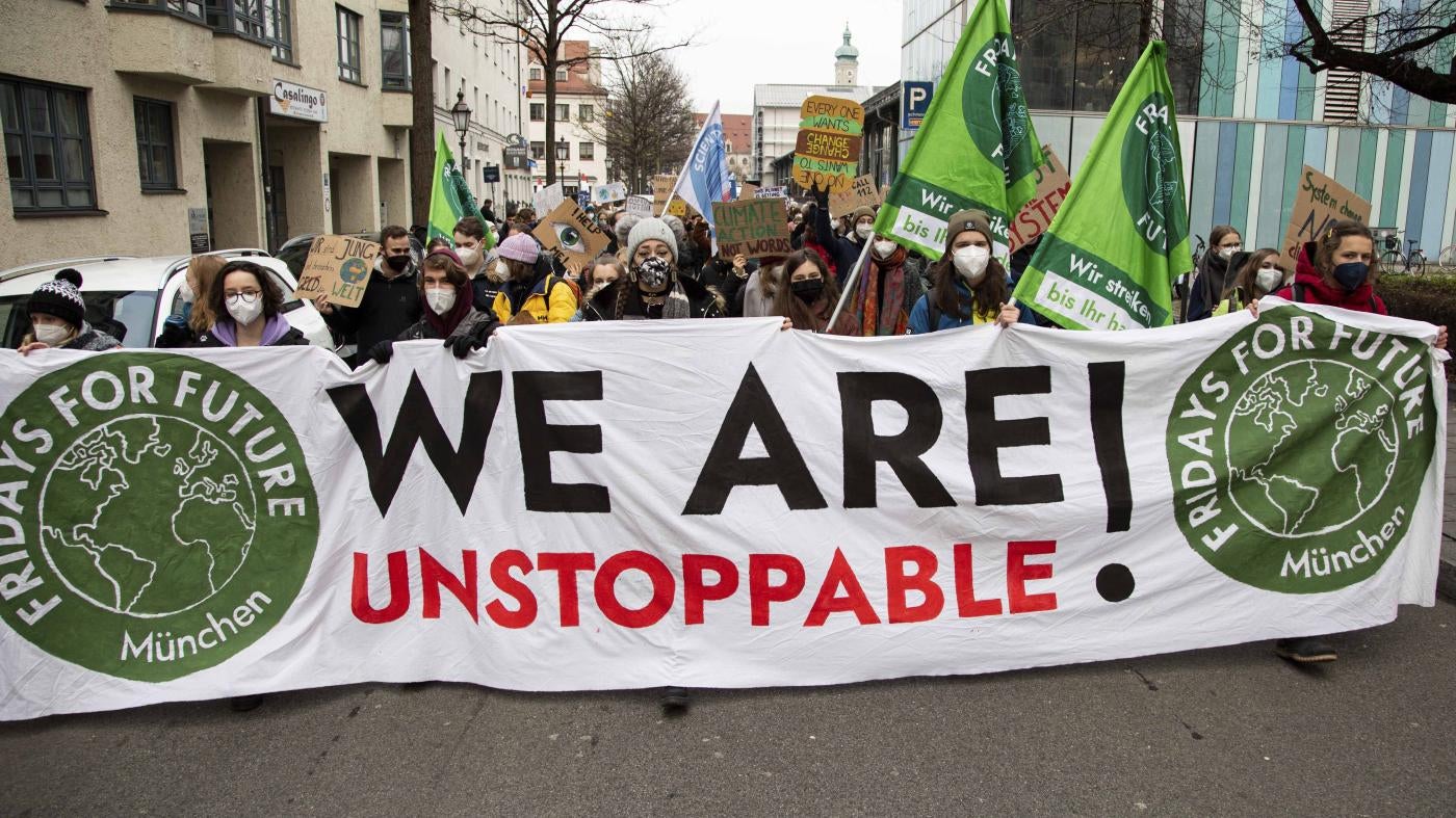 Protesters march with a banner that reads "We Are Unstoppable!"