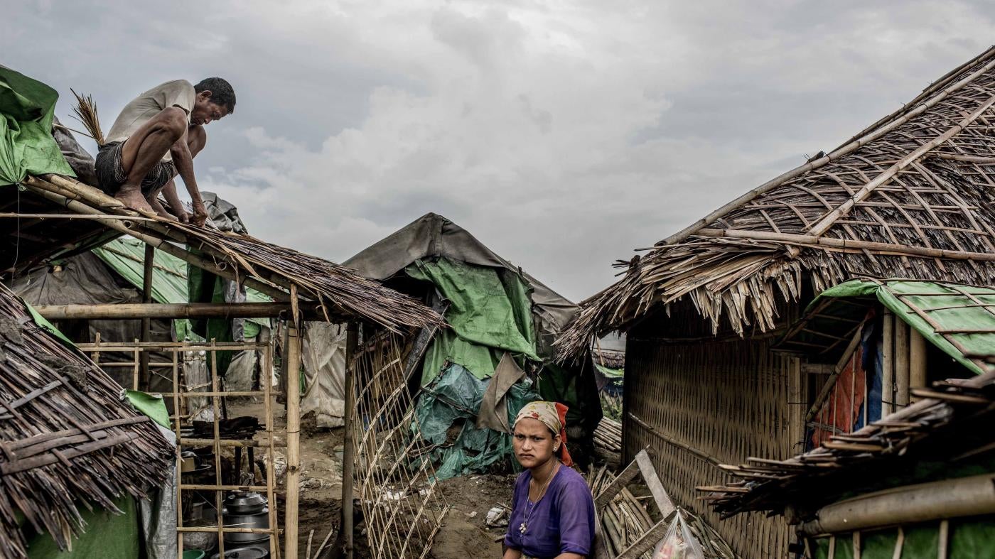 A Rohingya man fixes his roof