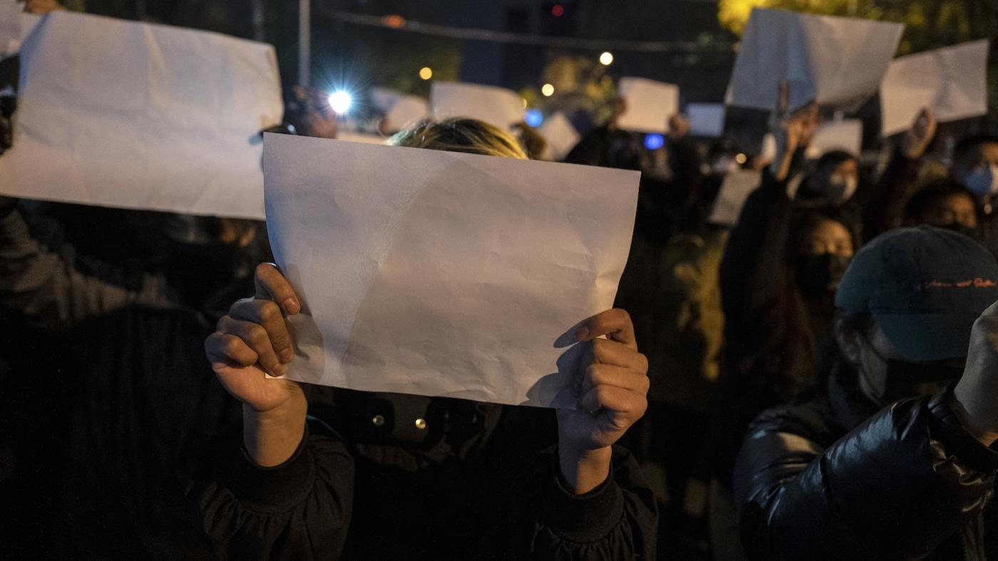  北京示威者举起白纸，抗议中国国家主席习近平的“清零”政策，2022年11月27日。
 © 2022 Kevin Frayer/Getty Images