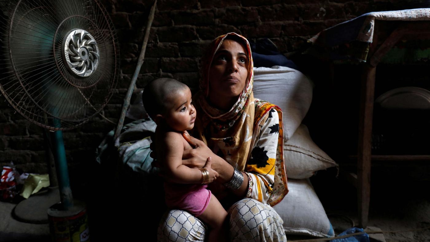  Razia, 25, and her 6-month-old daughter, Tamanna, sit in front of a fan to cool off during a heatwave, in Jacobabad, Pakistan, May 15, 2022.
 © 2022 Akhtar Soomro/Reuters
