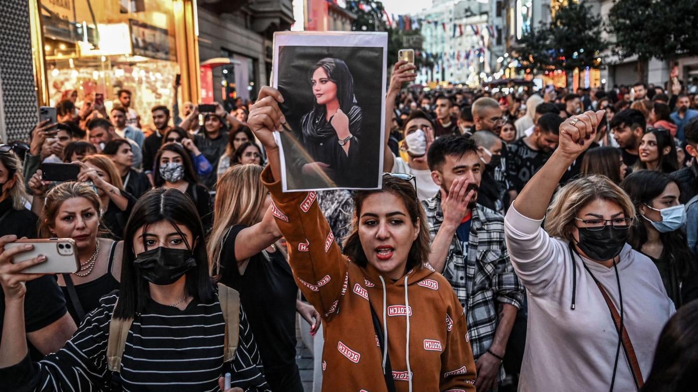  抗議者手持艾米尼畫像參加2022年9月20日在土耳其伊斯坦布爾舉行的示威活動。艾米尼因穿戴「不合格頭巾」在伊朗德黑蘭被「道德警察」拘留期間喪生，引發伊朗全國和世界各地民間抗議。
 © 2022 Ozan Kose/AFP/Getty Images