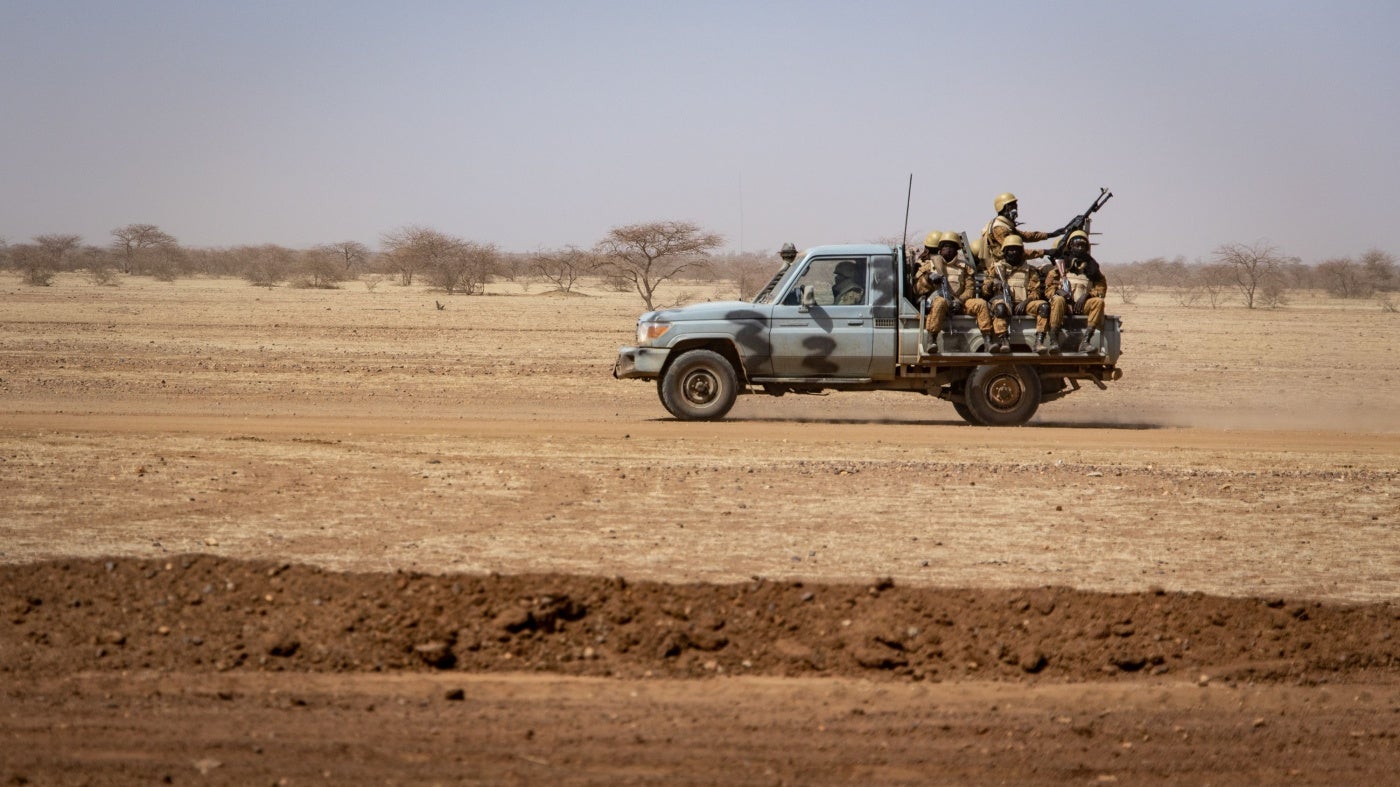 Des soldats burkinabè patrouillaient à bord d'un pick-up sur la route reliant la ville de Dori au camp de réfugiés de Goudebo, au Burkina Faso, le 3 février 2020. 