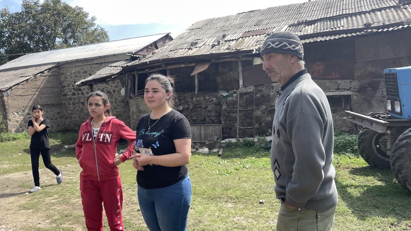 Ariana, 11, Amanda, 18, Agnessa, 22 with their grandfather Roma in front of a shed in Tatev, Armenia, the day after their long journey from Nagorno-Karabakh, September 29, 2023.