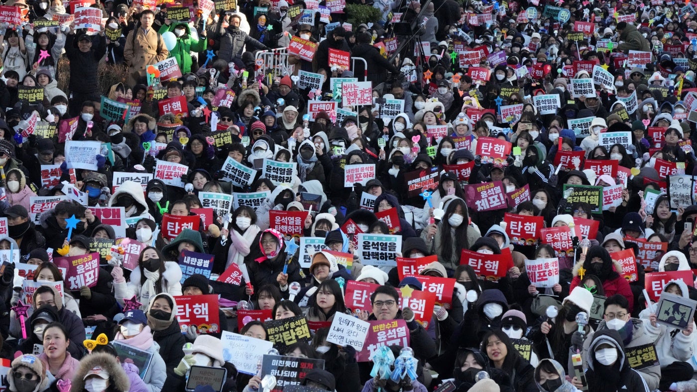 Protesters gather holding banners demanding the impeachment of South Korea's president