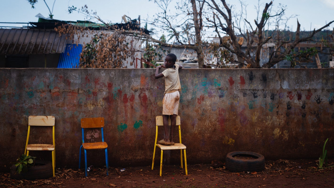A boy looks over a school fence 