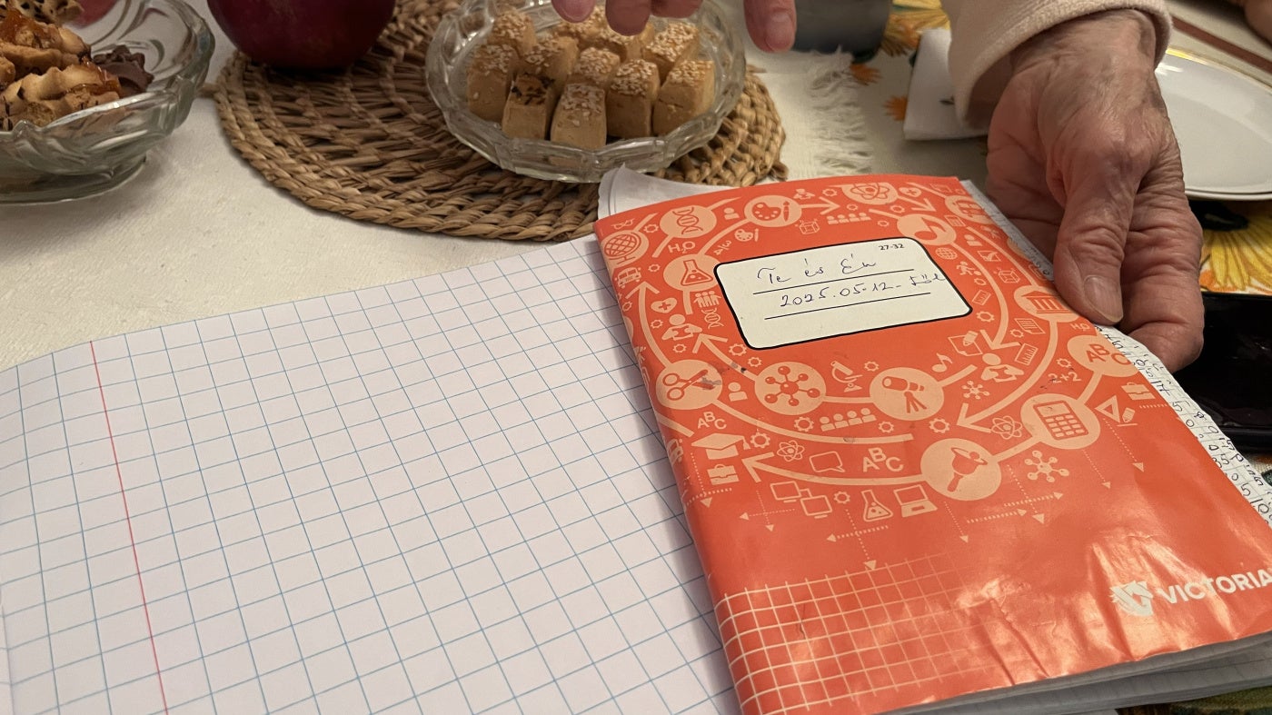 Anna, une femme hongroise âgée de 80 ans, montrait un carnet contenant des relevés détaillés des dépenses mensuelles effectuées sa sœur Erika, 84 ans, et elle-même, dans leur domicile à Budapest, en octobre 2025. 