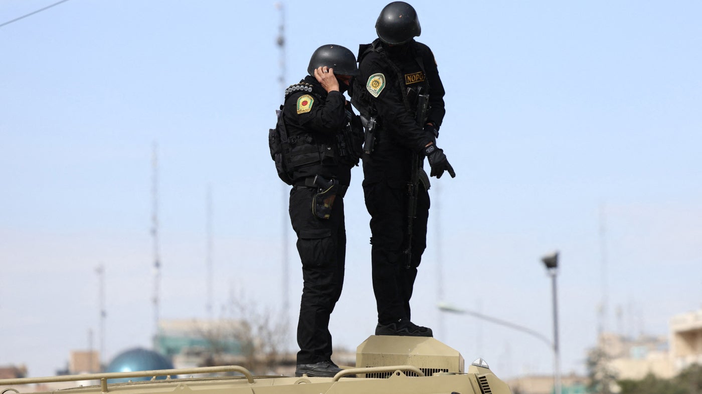 Iranian security forces stand guard on top of an armored vehicle in Tehran on March 21, 2026.