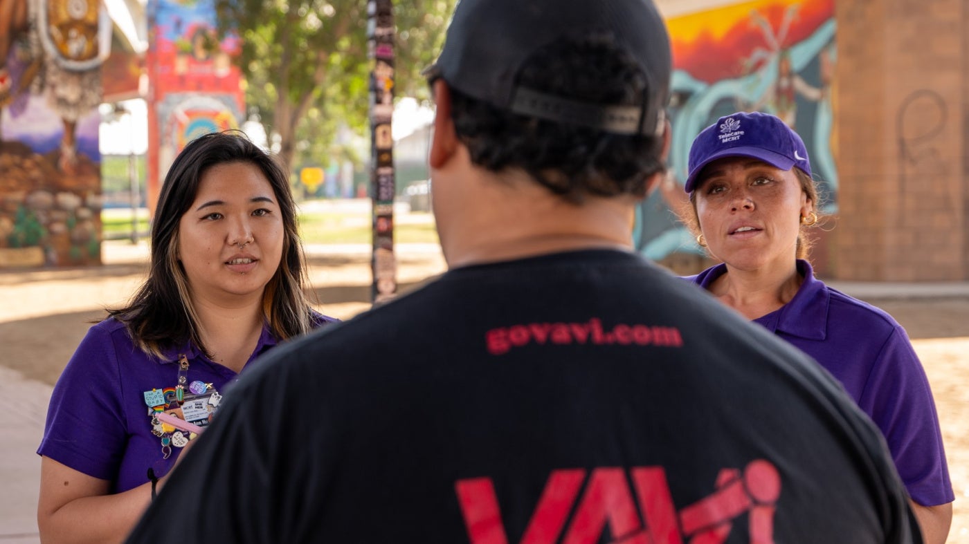 Two crisis response team members speak to a man 