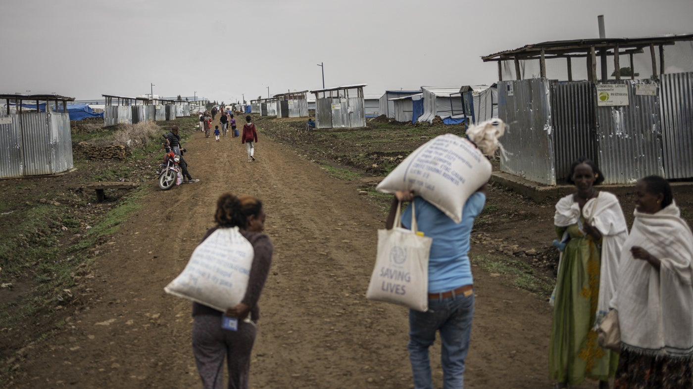 Internally displaced people carry food parcels during a distribution at Seba Care displaced persons camp in Mekelle, Tigray region, Ethiopia, July 19, 2024.
