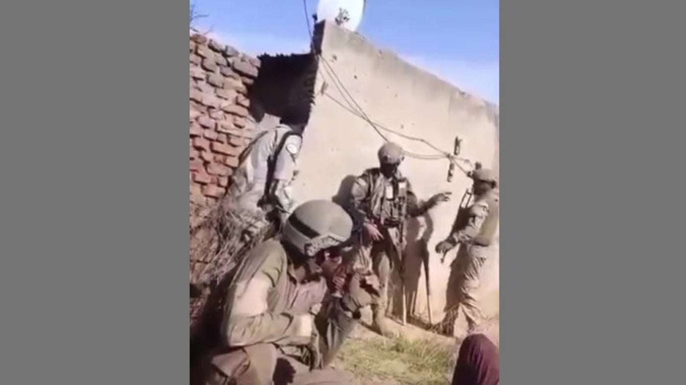 Des contractuels militaires privés parlaient en espagnol près d’un combattant des Forces de soutien rapide, ou FSR (à gauche) derrière le mur d’une maison à El Fasher, capitale du Nord-Darfour au Soudan. 