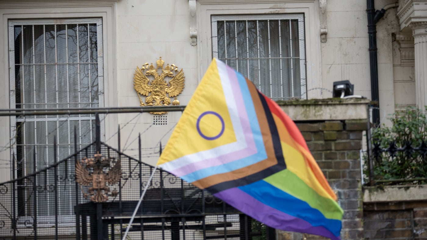 A Pride flag near the Russian coat of arms during a protest outside the Russian embassy in London, March 16, 2023.
