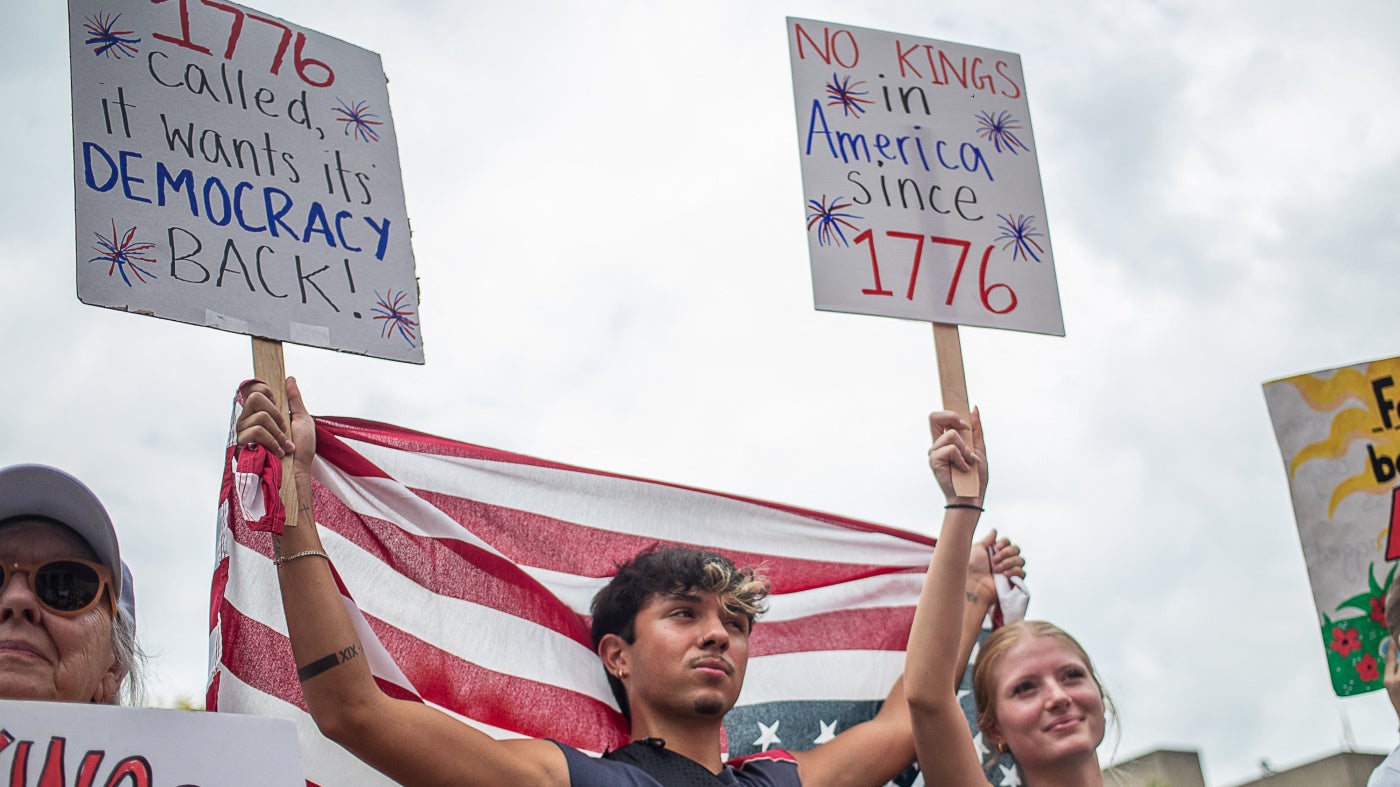 Protesters hold US flags and placards during a nationwide "No Kings" rally
