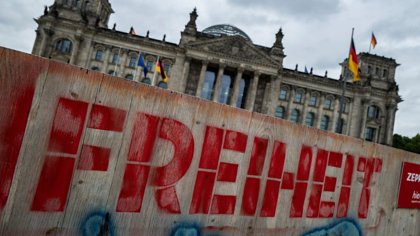 Auf einem Holzzaun vor dem Reichstagsgebäude in Berlin ist das Wort „Freiheit“ zu lesen.