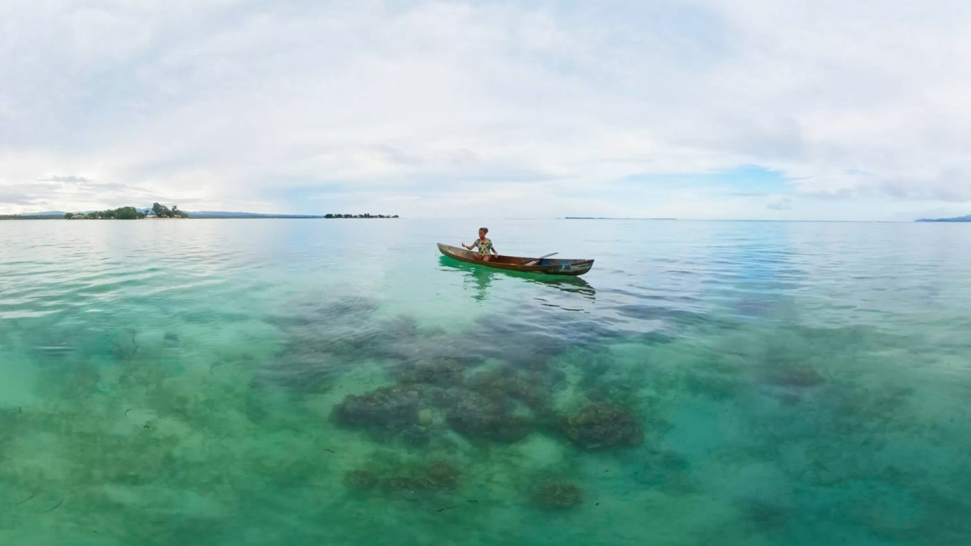 A girl in her fishing boat off the coast of Malaita Province, Solomon Islands. 
