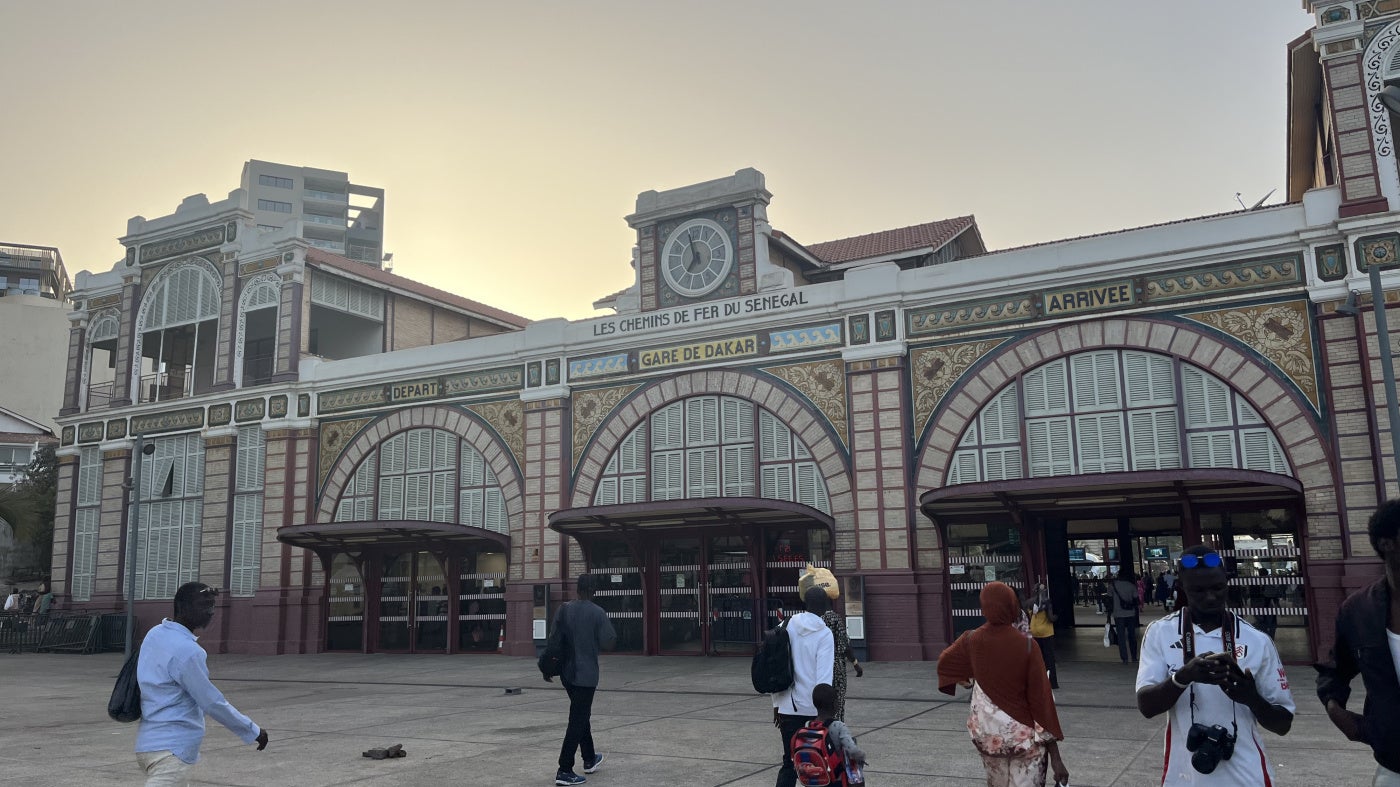 Des passants marchaient devant la gare ferroviaire rénovée de Dakar, au Sénégal, en mai 2026.