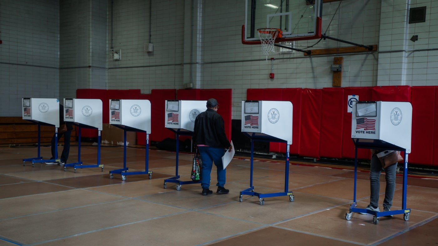 A voter carries a ballot during early voting in the New York City mayoral elections on October 25, 2025.
