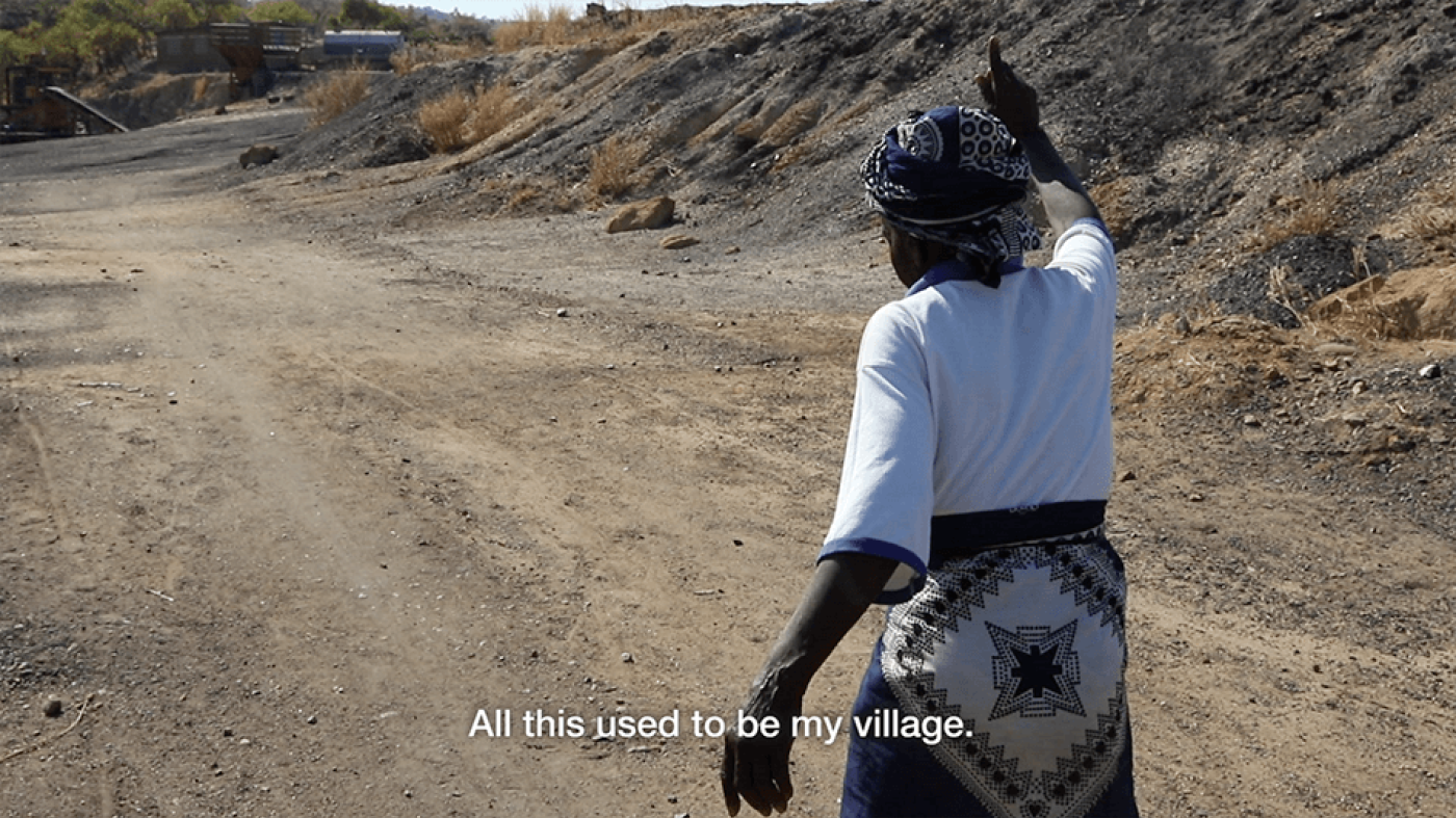 A picture of a woman pointing and saying. "All this used to be my village."