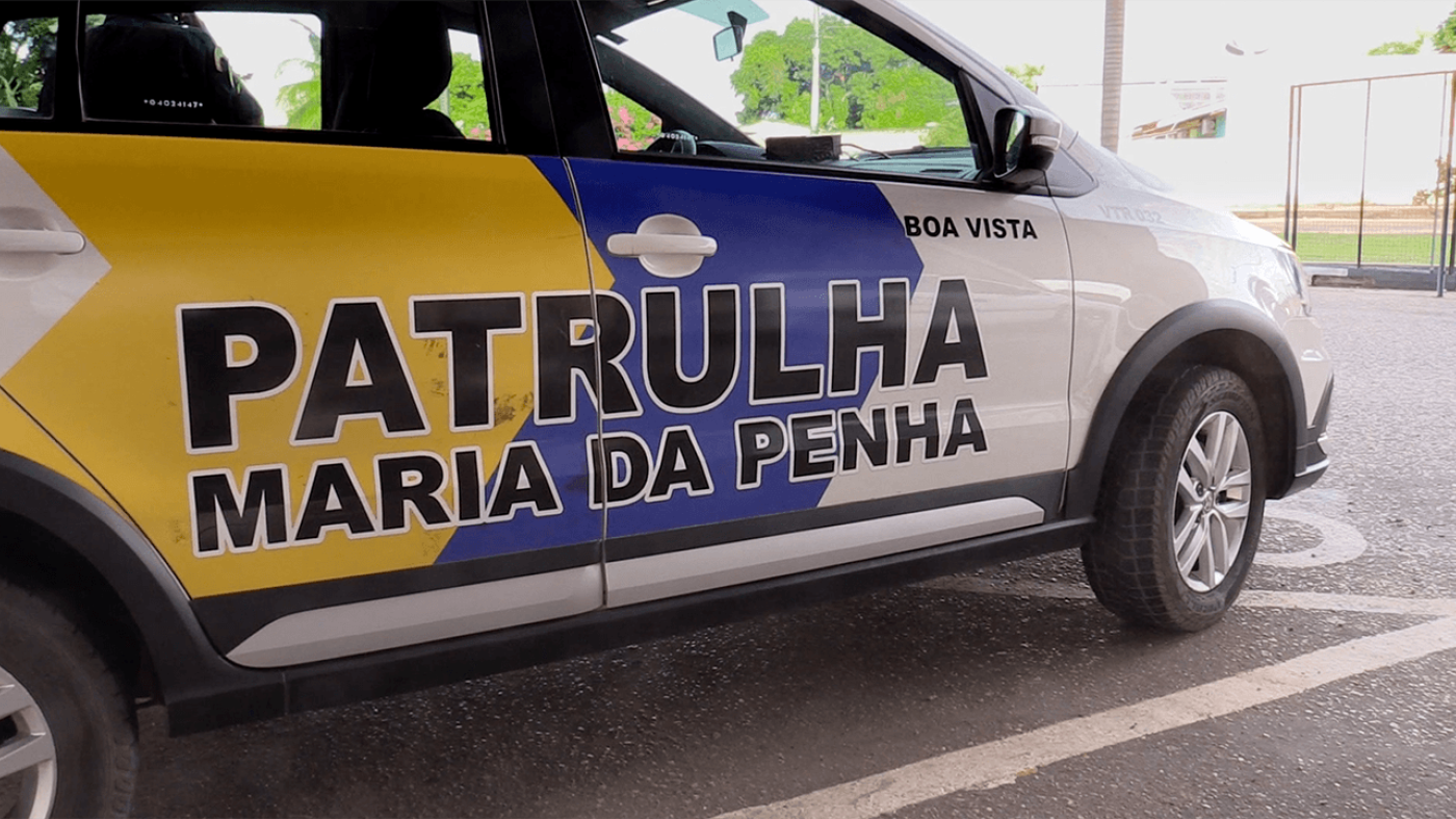 A close-up of a Brazilian police car with the words "Patrulha Maria da Pena" on its side.
