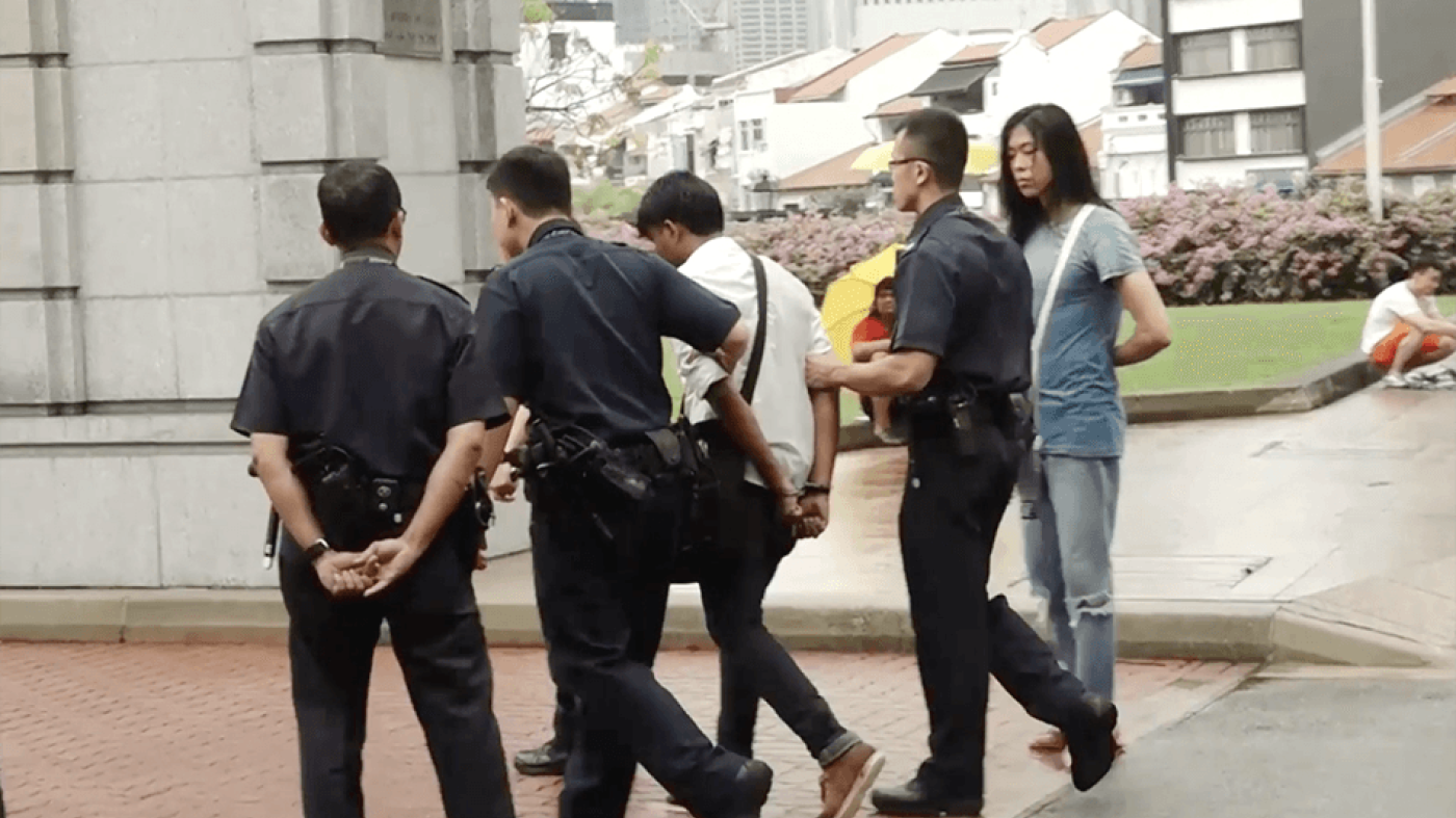 Photo of an activist being arrested in Singapore.