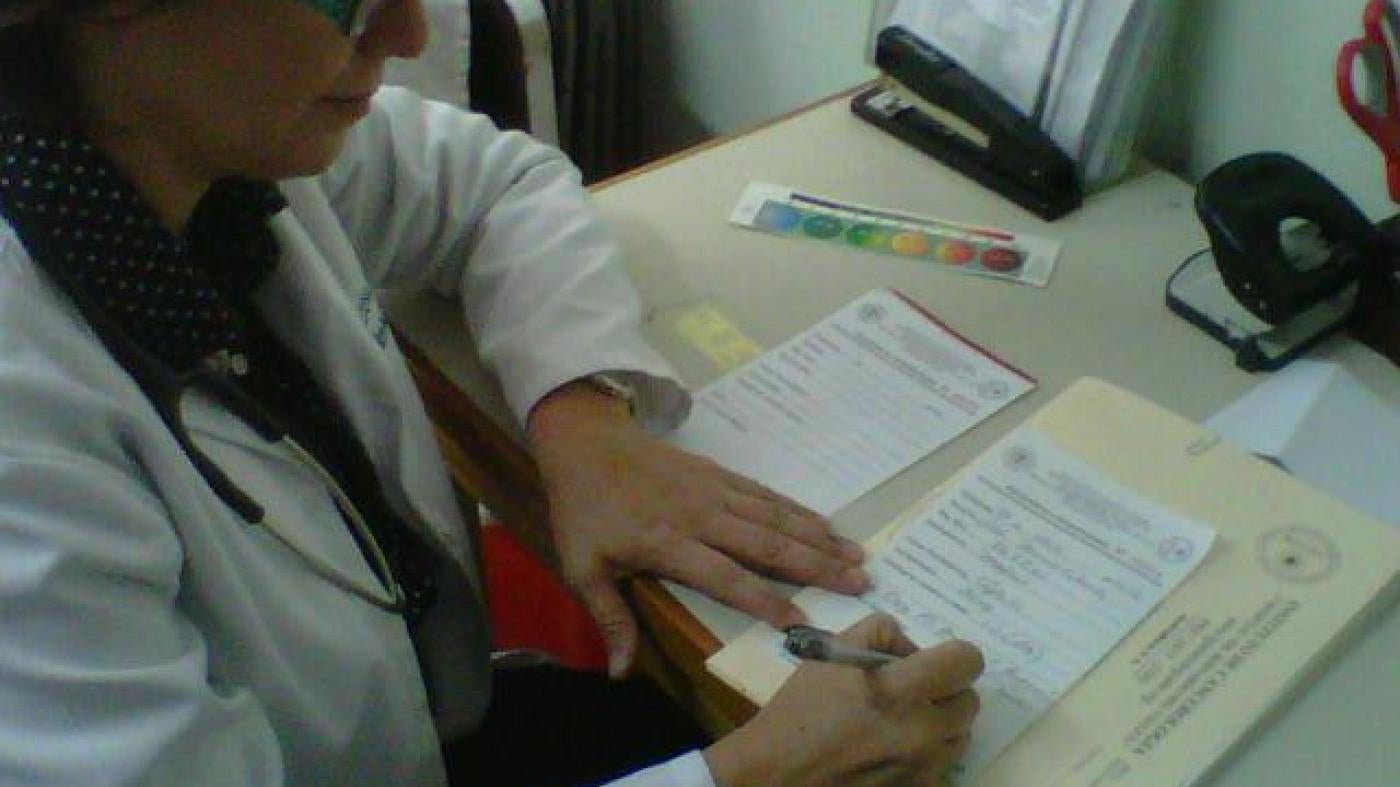 Dr. Eva Duarte writing prescriptions for her patients