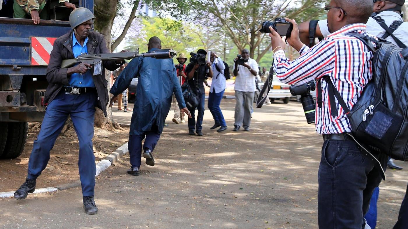 An anti-riot police officer aims a teargas canister while journalists cover an anti-corruption protest in Kenya's capital, Nairobi. November 3, 2016. 