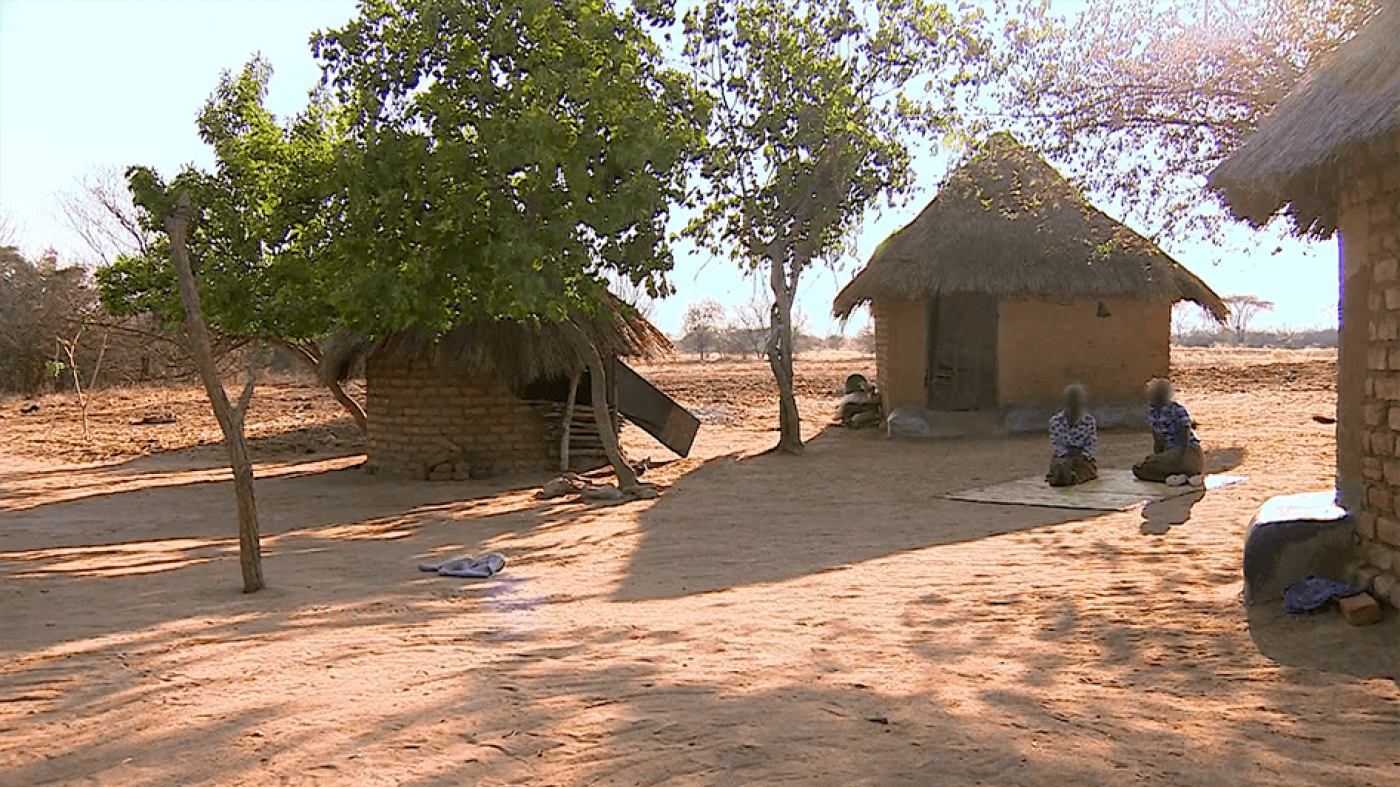 Two widows sitting outside their hut in Zimbabwe.