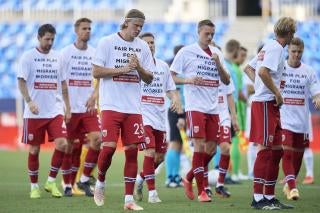 Members of a football team wear t-shirts calling for human rights for migrant workers 