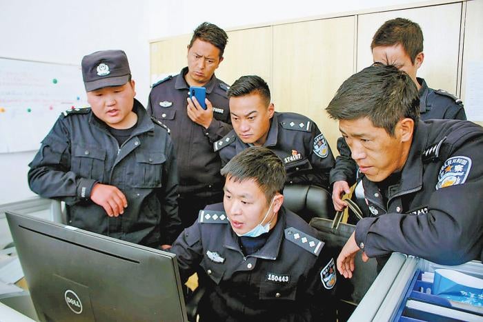 People’s Police at the new Fengqiao-style police post in Chushul County, Lhasa Municipality, Tibet Autonomous Region, discussing their work.