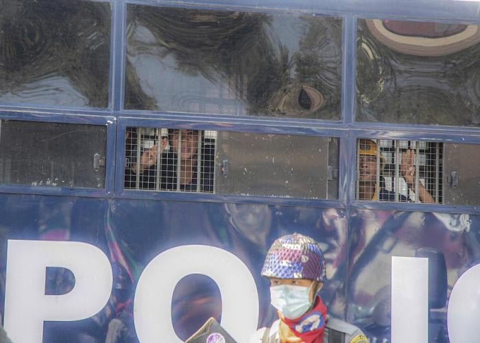 Protesters raise three-finger salutes from inside a police vehicle after a being detained during an anti-coup protest in Mandalay, Myanmar, February 9, 2021.