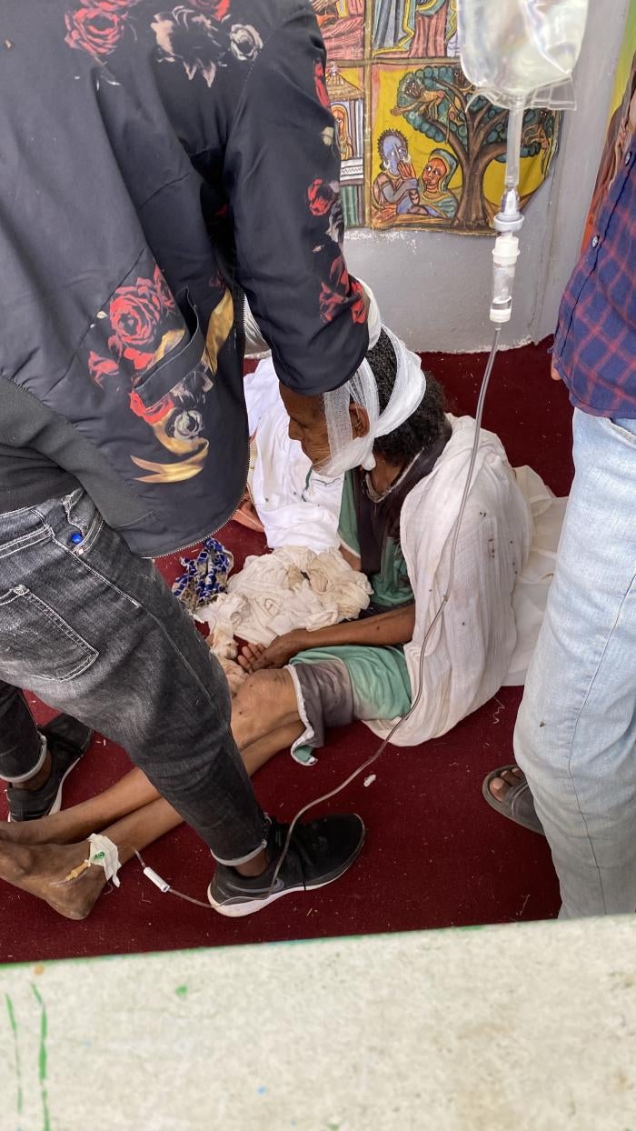 A woman, injured by shelling during the Ethiopian and Eritrean military in Axum, sits on the floor as she receives medical care. The image was taken on November 30, 2020 according to the photograph&rsquo;s metadata.
