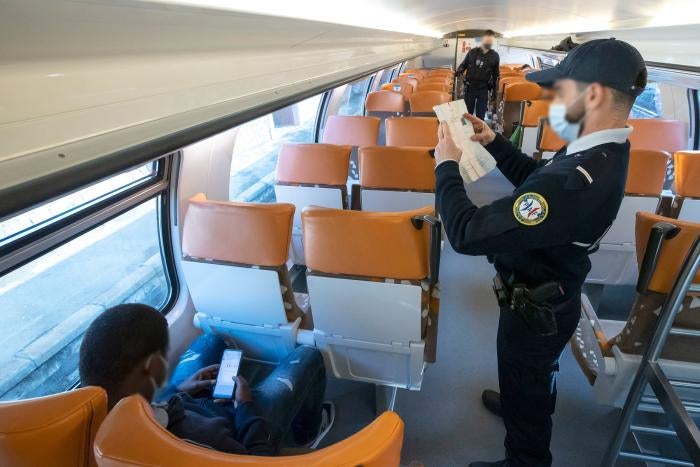 A member of the French border police checks identity documents in March 2021 at the Menton-Garavan station, the first French train station for those travelling between Genoa, in Italy, and Nice, in France.