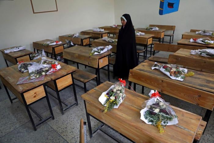 The mother of a schoolgirl who was among those killed in the brutal May 8, 2021 bombing of the Sayed ul-Shuhada girls' school stands inside a classroom with bouquets of flowers on empty desks as a tribute to the dead, in Kabul, Afghanistan, May 16, 2021.&nbsp;