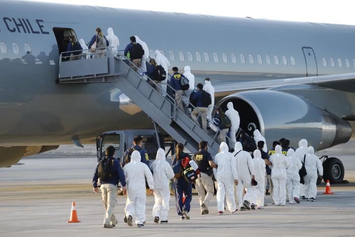 Venezuelan migrants board a plane as they are being deported from Chile, at the General Diego Aracena Aguilar International Airport&nbsp;in Iquique, Chile, on February 10, 2021.&nbsp;
