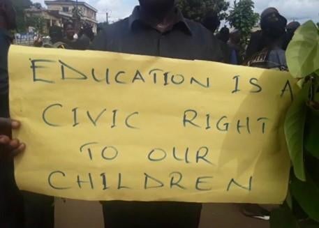 A yellow protest sign that says "Education is a civic right to our children!"